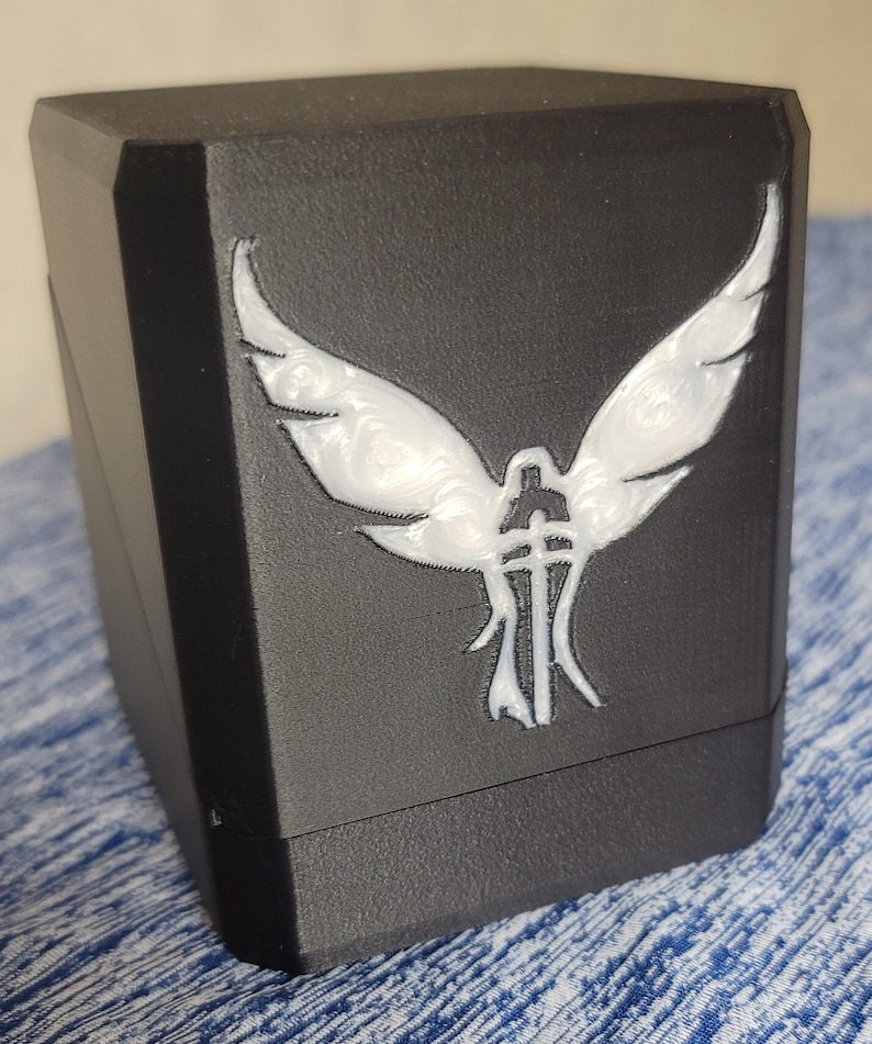 Black Deck Companion box with a white resin angel and sword design